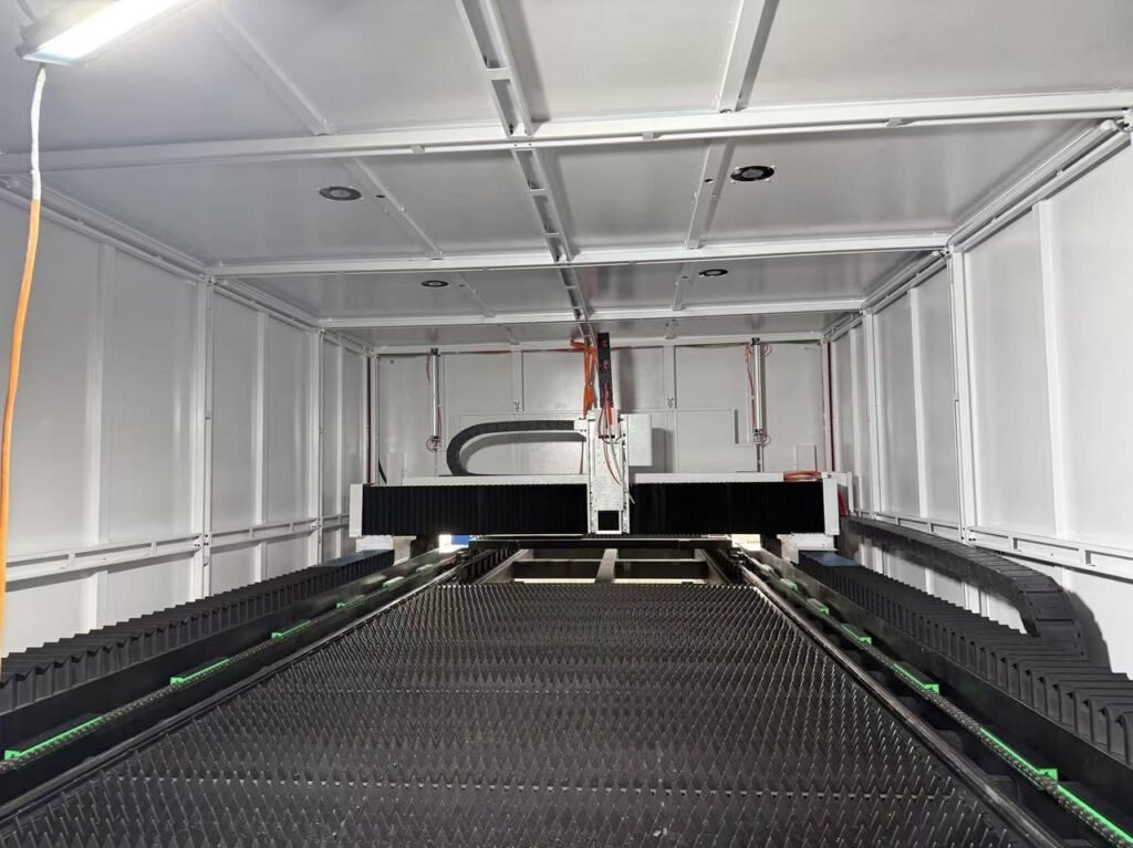 Interior of an enclosed laser cutting machine with its slat bed and cutting gantry